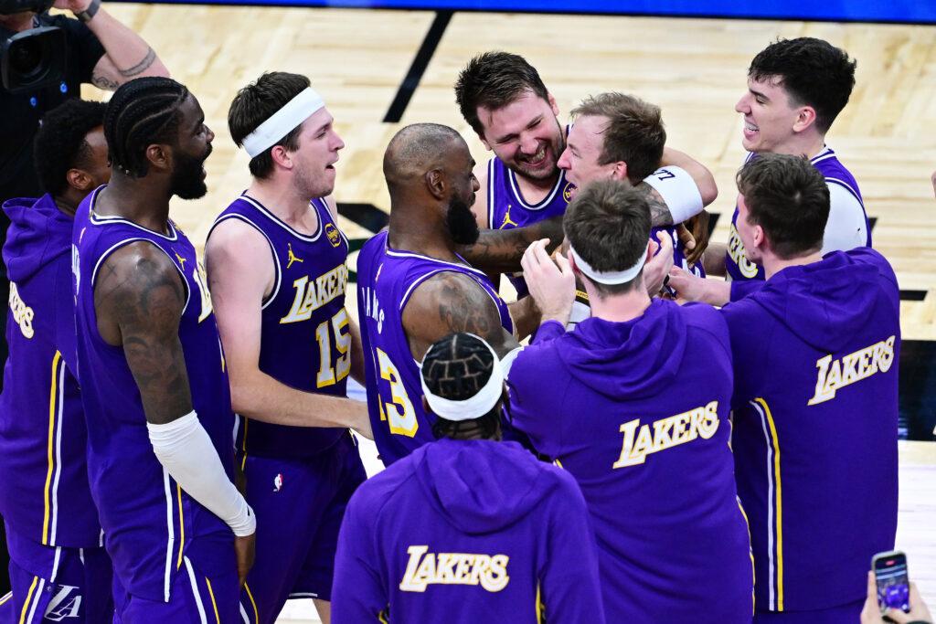 Luke Kennard #10 of the Los Angeles Lakers celebrates with Deandre Ayton #5, Austin Reaves #15, LeBron James #23, Luka Doncic #77, and Jake LaRavia #12 after scoring a go-ahead three-point-basket in the fourth quarter against the Orlando Magic at Kia Center.