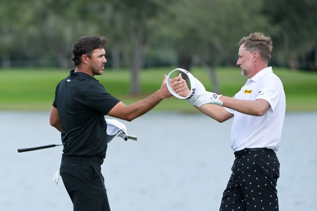Brooks Koepka shakes hands with Ian Poulter on the seventh green during the semifinals of the LIV Golf Invitational - Miami