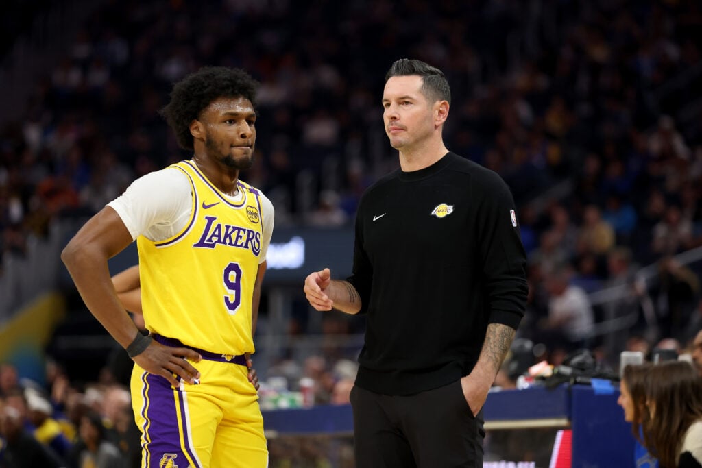 Los Angeles Lakers head coach JJ Redick talks to Bronny James #9 during the first half of their preseason game against the Golden State Warriors at Chase Center.