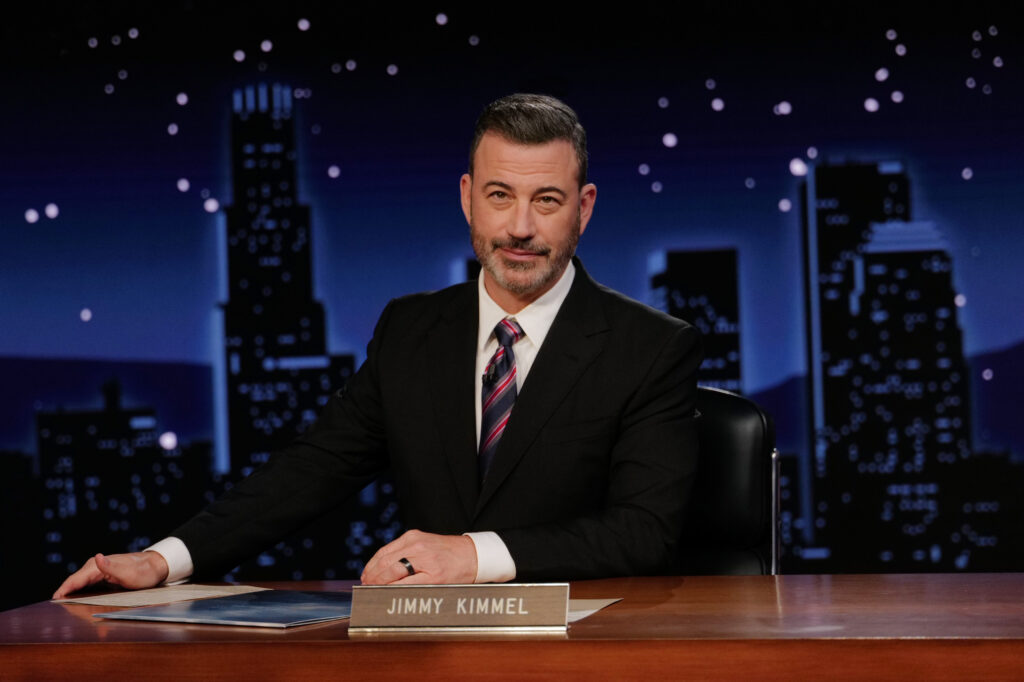 Jimmy Kimmel, the host of 'Jimmy Kimmel Live!' sits at a desk.