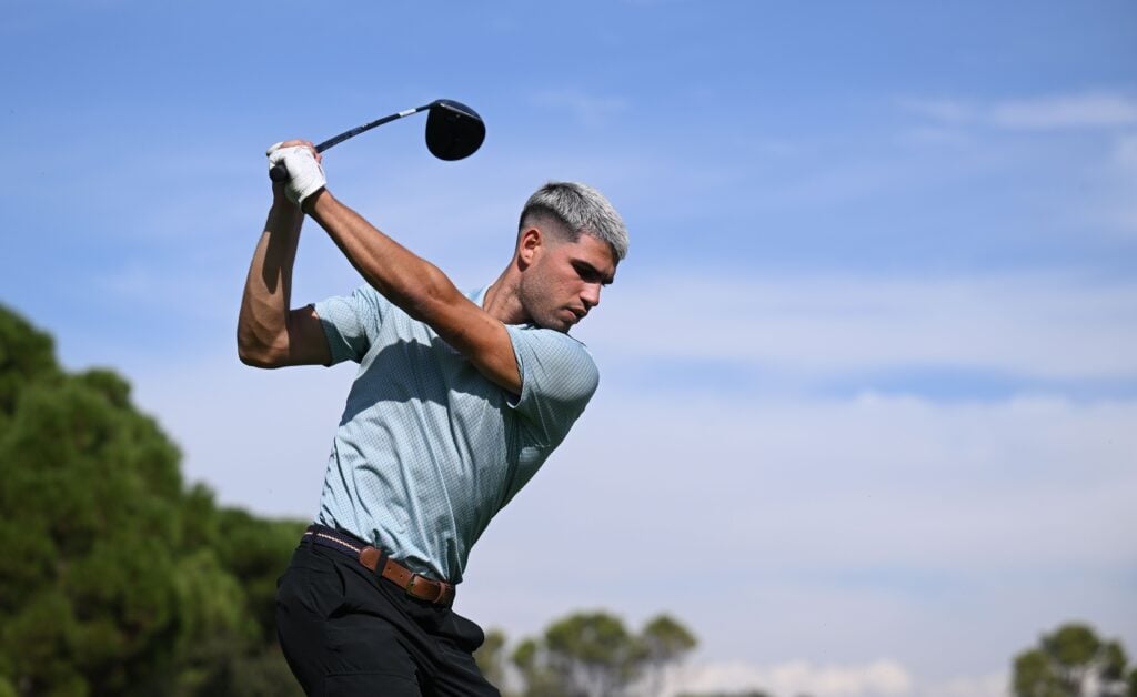 Carlos Alcaraz hits a golf shot in Madrid in 2025