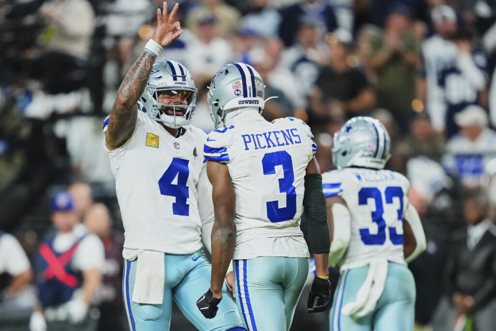 Dak Prescott #4 of the Dallas Cowboys celebrates after scoring a touchdown with teammate George Pickens #3 against the Las Vegas Raiders during an NFL football game at Allegiant Stadium.