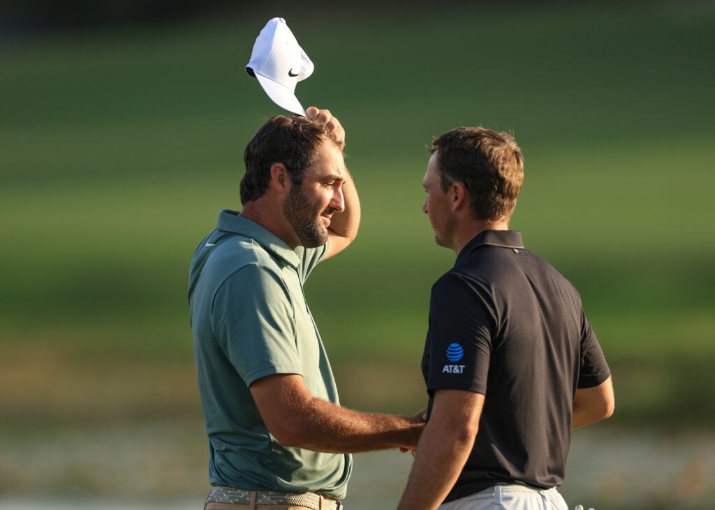 Scottie Scheffler shakes hands with Jordan Spieth on the 18th hole during the first round of the Hero World Challenge