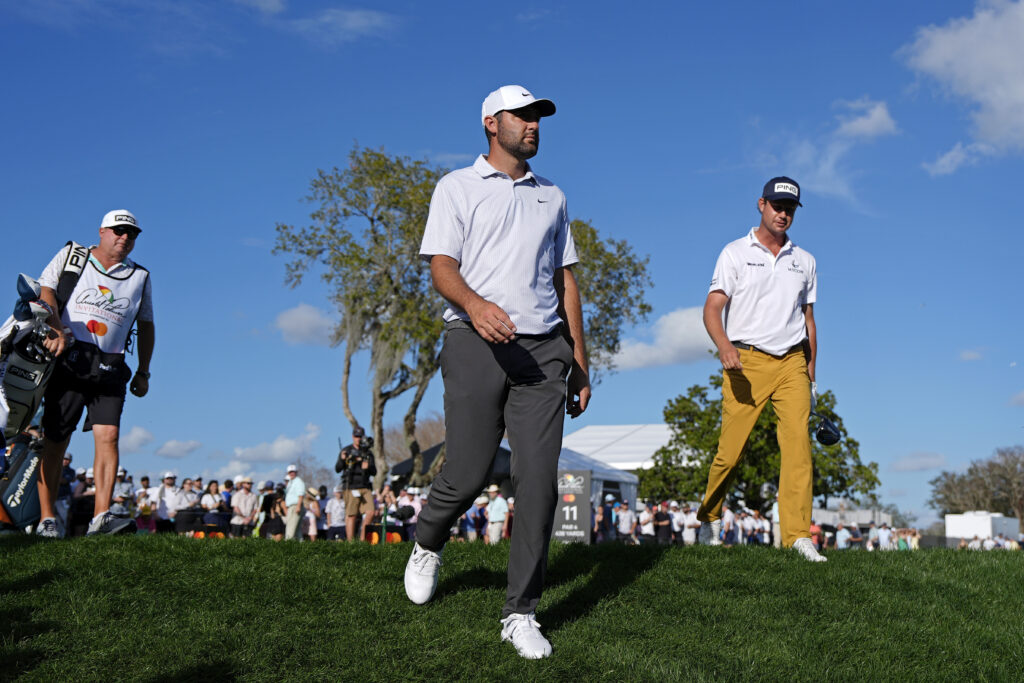 Scottie Scheffler and Harris English walk off the tee box at the 15th hole during the third round of the Arnold Palmer Invitational