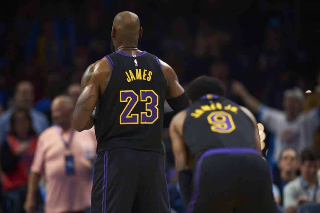 LeBron James #23 of the Los Angeles Lakers shoots a free throw while Bronny James #9 of the Los Angeles Lakers looks on against the Oklahoma City Thunder at the Paycom Center.