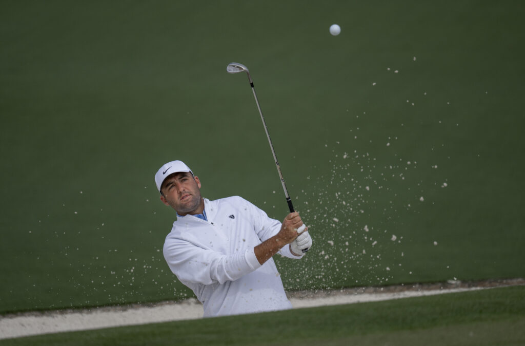 Scottie Scheffler hits from a bunker during a practice round ahead of The Masters