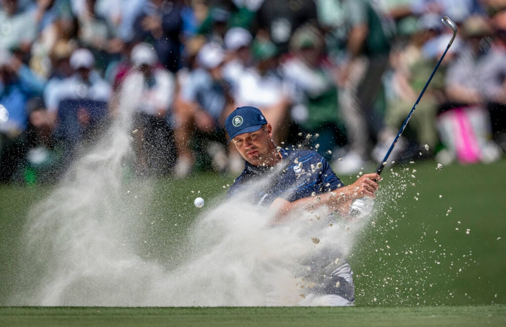 Bryson DeChambeau of the United States plays a stroke from a bunker on the No. 11 hole during the first round of the Masters at Augusta National Golf Club