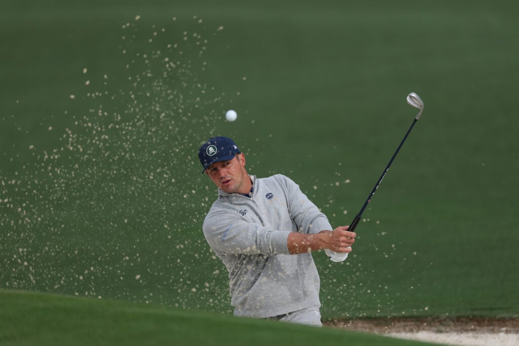Bryson DeChambeau hits out of a bunker during a practice round ahead of The Masters