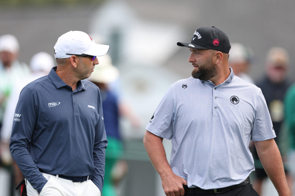 Sergio Garcia of Spain talks with Jon Rahm of Spain as they play the 10th hole during a practice round prior to the 2026 Masters Tournament at Augusta National Golf Club