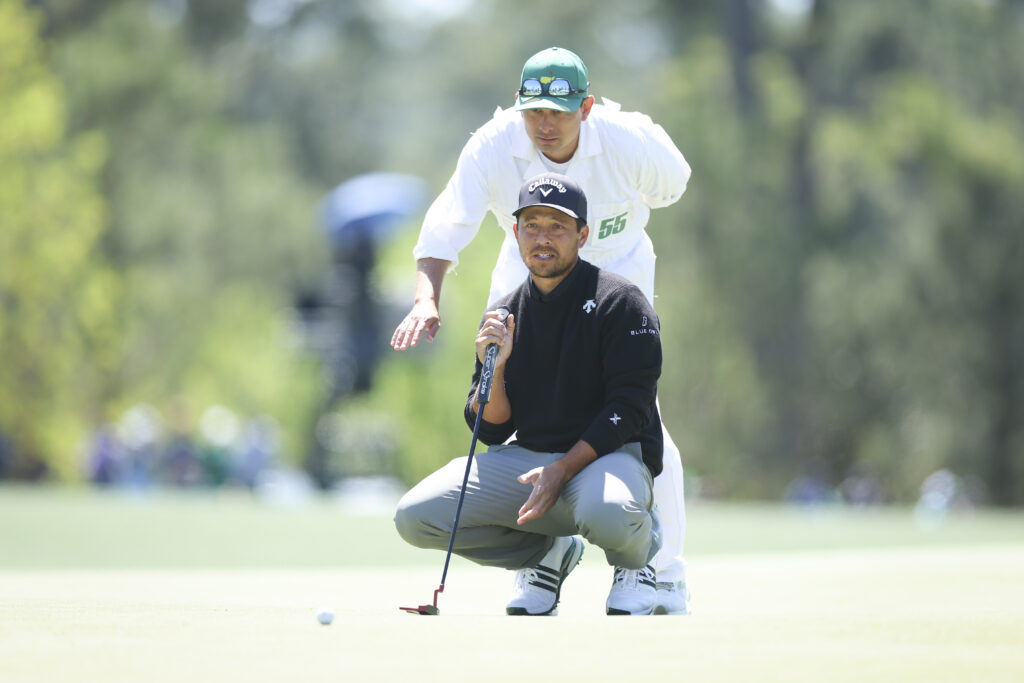 Xander Schauffele lines up a putt with his caddie Austin Kaiser on the eighth green during the first round of the 2026 Masters Tournament at Augusta National Golf Club