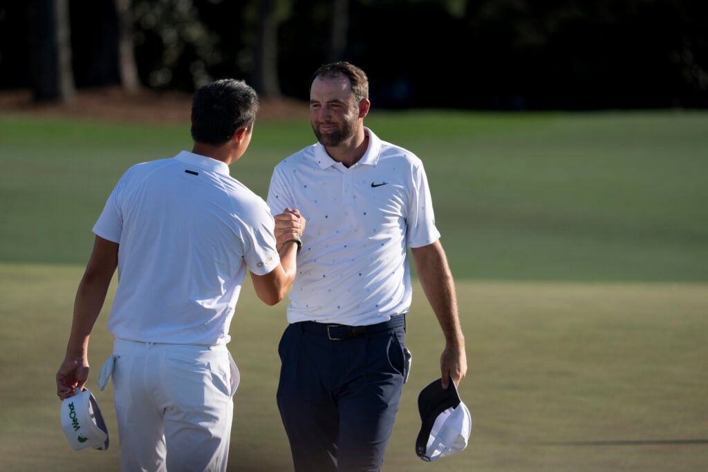 Masters champion Scottie Scheffler of the United States greets Haotong Li of China on the No. 18 green during the final round of the Masters at Augusta National Golf Club