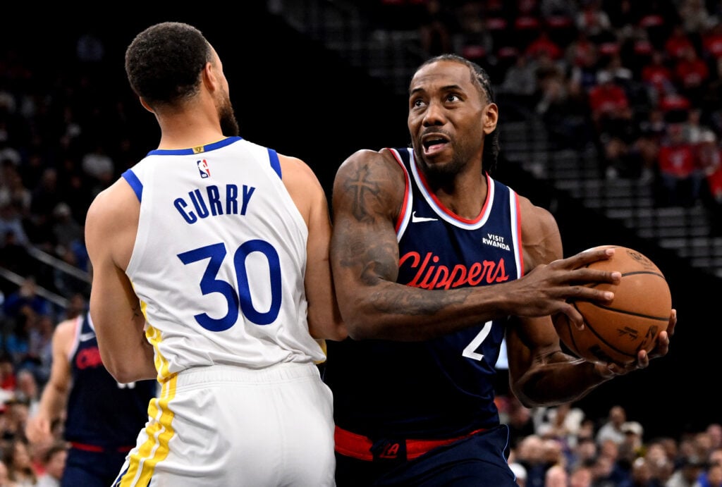 Forward Kawhi Leonard #2 of the LA Clippers drives to the basket against guard Stephen Curry #30 of the Golden State Warriors in the first half of a NBA play-in tournament basketball game at Intuit Dome.