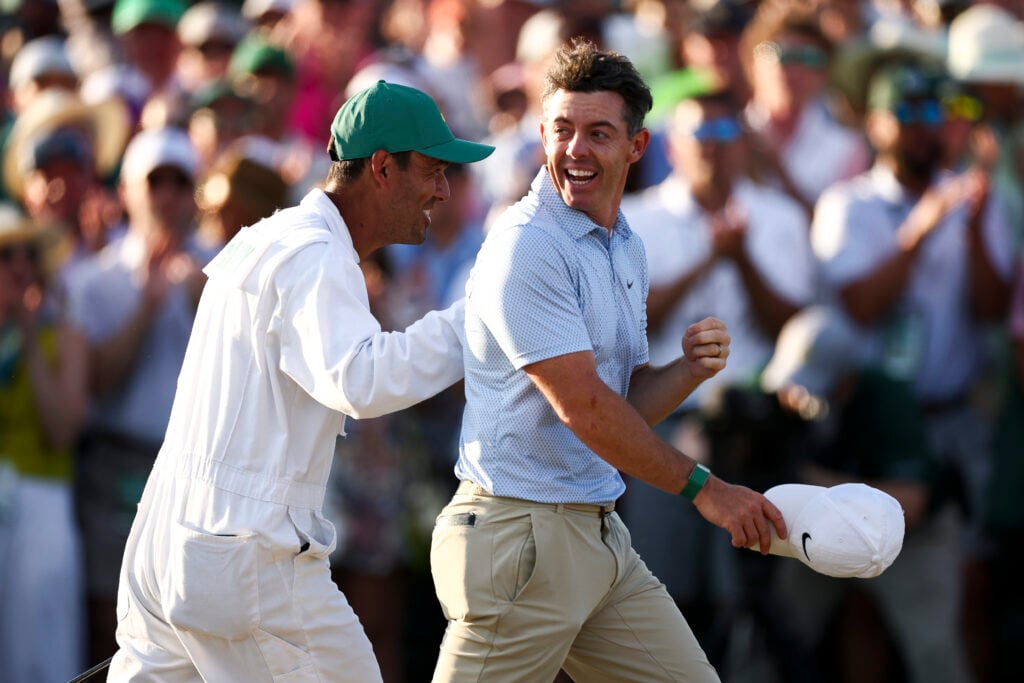 Rory McIlroy of Northern Ireland and his caddie Harry Diamond celebrate winning the 2026 Masters Tournament on the 18th green at Augusta National Golf Club