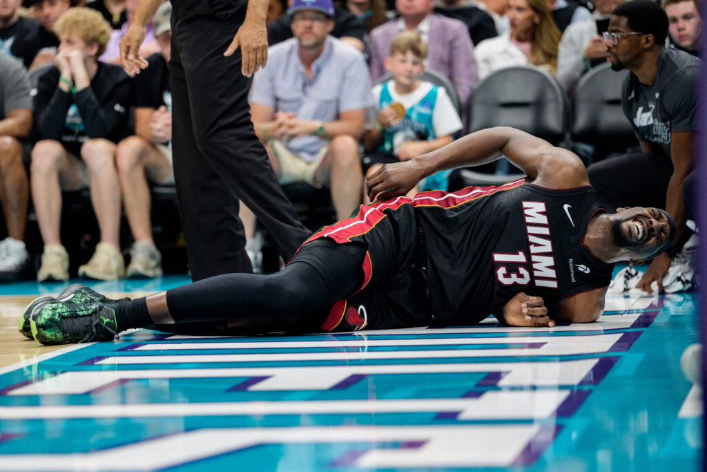 Bam Adebayo #13 of the Miami Heat reacts after a fall in the first half against the Charlotte Hornets during their game at Spectrum Center.