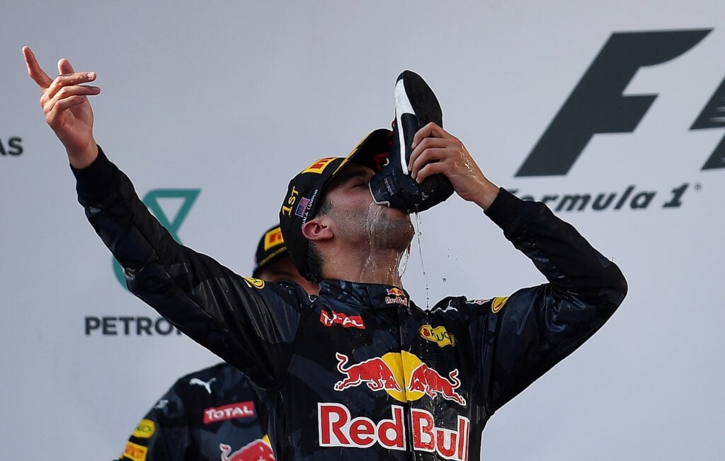 Red Bull Racing's Australian driver Daniel Ricciardo drinks champagne from his shoe as he celebrates his victory on the podium during the Formula One Malaysian Grand Prix in Sepang on October 2, 2016.