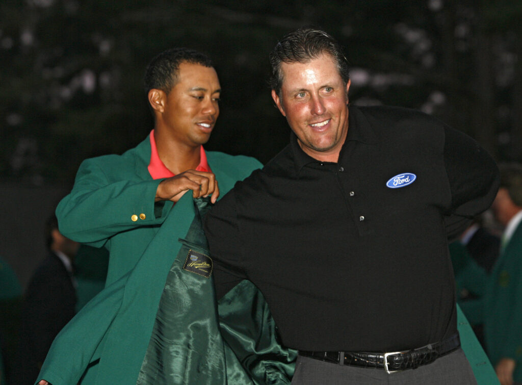 Phil Mickelson receives his green jacket from Tiger Woods after winning the 2006 Masters at the Augusta National