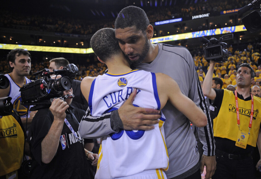 San Antonio Spurs' Tim Duncan (21) hugs Golden State Warriors' Stephen Curry (30) after Game 6 of the Western Conference semifinals at Oracle Arena.