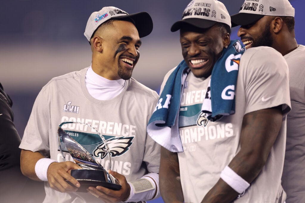 Jalen Hurts #1 of the Philadelphia Eagles holds the George Halas Trophy with A.J. Brown #11 after defeating the San Francisco 49ers to win the NFC Championship Game at Lincoln Financial Field.