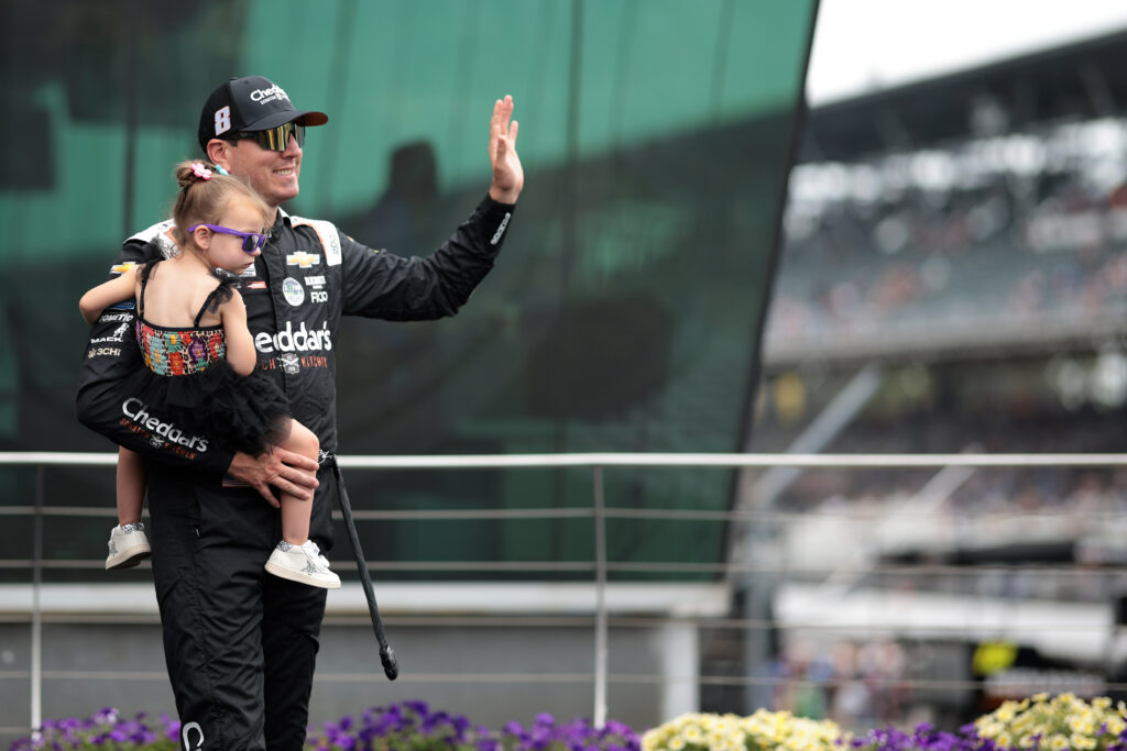Kyle Busch, driver of the #8 Cheddar's Patriotic Chevrolet, waves to fans as he walks onstage during driver intros prior to the NASCAR Cup Series Brickyard 400 at Indianapolis Motor Speedway on July 21, 2024 in Indianapolis, Indiana.