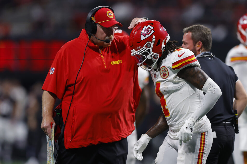 Head coach Andy Reid of the Kansas City Chiefs speaks with Rashee Rice #4 of the Kansas City Chiefs during the third quarter against the Atlanta Falcons at Mercedes-Benz Stadium.