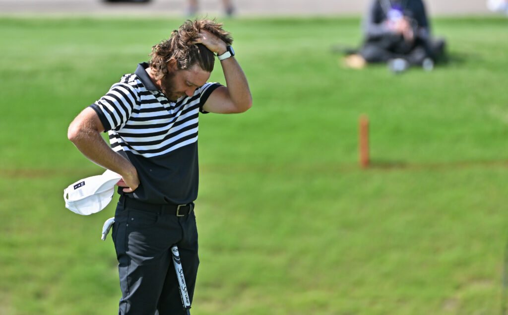 Tommy Fleetwood runs his hand through his hair while standing on the eighteenth green during the third round of the Charles Schwab Challenge