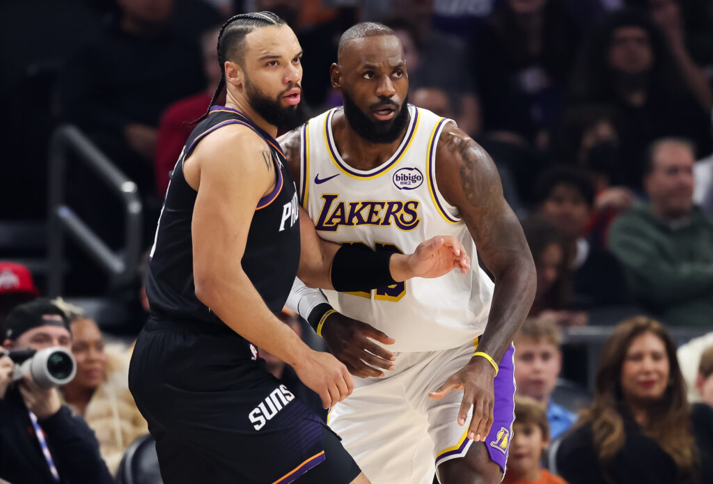Dillon Brooks #3 of the Phoenix Suns, left, is guarded by Lebron James #23 of the Los Angeles Lakers during the first half of a game at Mortgage Matchup Center.