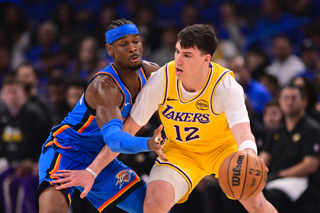 Jake LaRavia #12 of the Los Angeles Lakers works against Shai Gilgeous-Alexander #2 of the Oklahoma City Thunder during the first quarter in Game One of the Second Round of the NBA Western Conference Playoffs at Paycom Center.