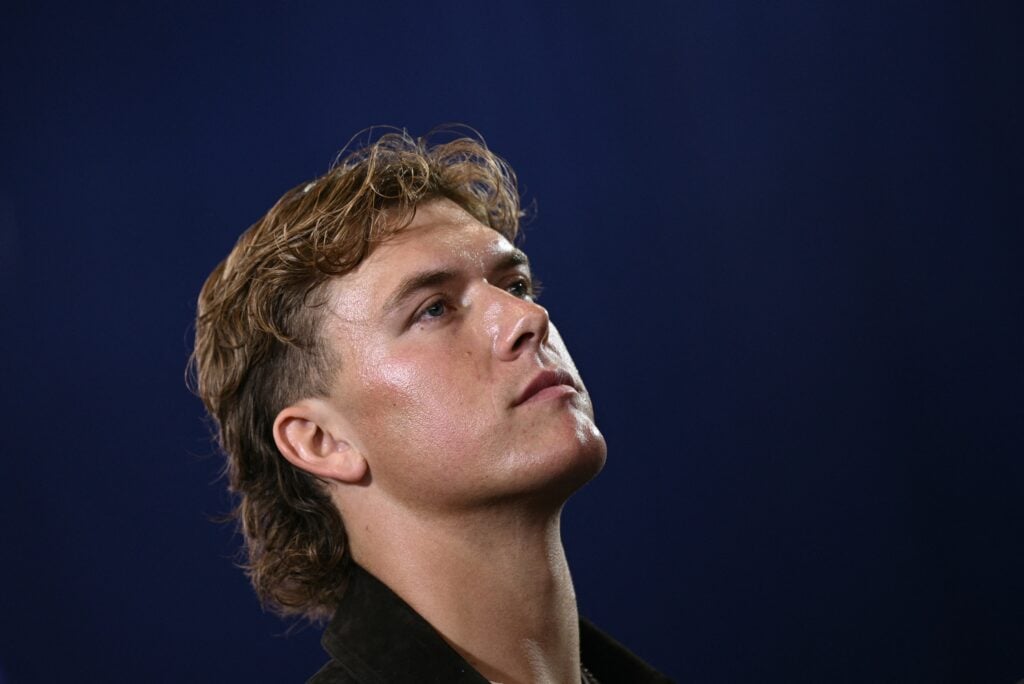 New York Giants quarterback Jaxson Dart looks on as the US president speaks about the economy at Rockland Community College Fieldhouse.