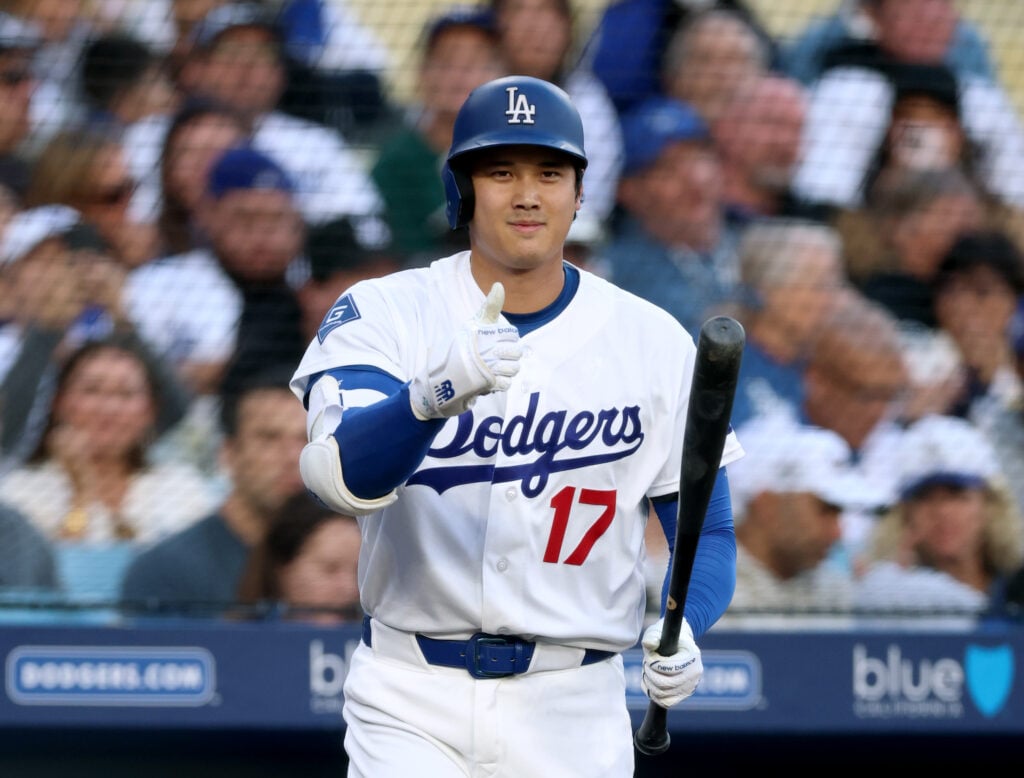 Shohei Ohtani #17 of the Los Angeles Dodgers signals his readiness to bat to the umpire, after pitching, during the first inning against the Colorado Rockies at Dodger Stadium.