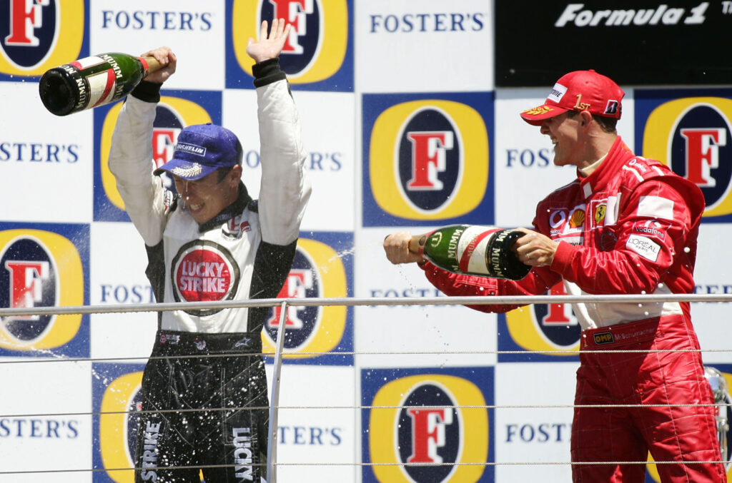 Michael Schumacher sprays Takuma Sato with champagne on the 2004 F1 United States Grand Prix podium