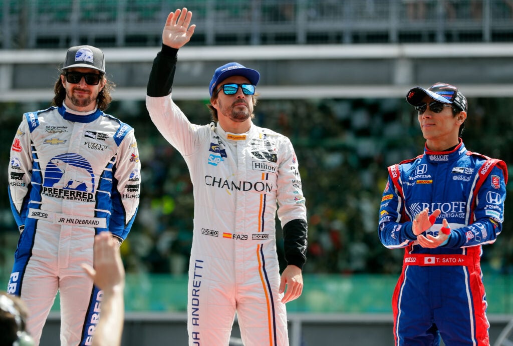 Fernando Alonso of Spain, driver of the #29 McLaren-Honda-Andretti Honda, waves during driver introductions alongside JR Hildebrand, driver of the #21 Preferred Freezer Service Chevrolet, and Takuma Sato of Japan, driver of the #26 Andretti Autosport Honda,ahead of the 101st running of the Indianapolis 500 at Indianapolis Motorspeedway on May 28, 2017 in Indianapolis, Indiana.