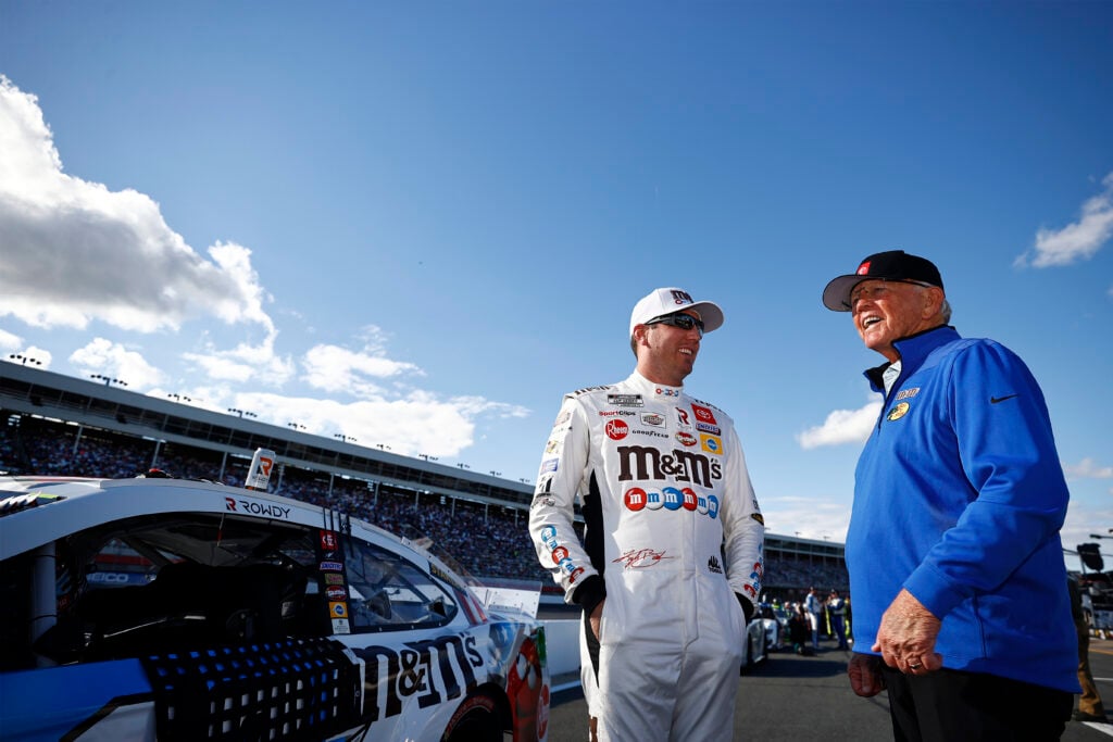 Kyle Busch, driver of the #18 M&M's Red White & Blue Toyota, and Hall of Famer and team owner Joe Gibbs talk on the grid prior to the NASCAR Cup Series Coca-Cola 600 at Charlotte Motor Speedway on May 30, 2021 in Concord, North Carolina.