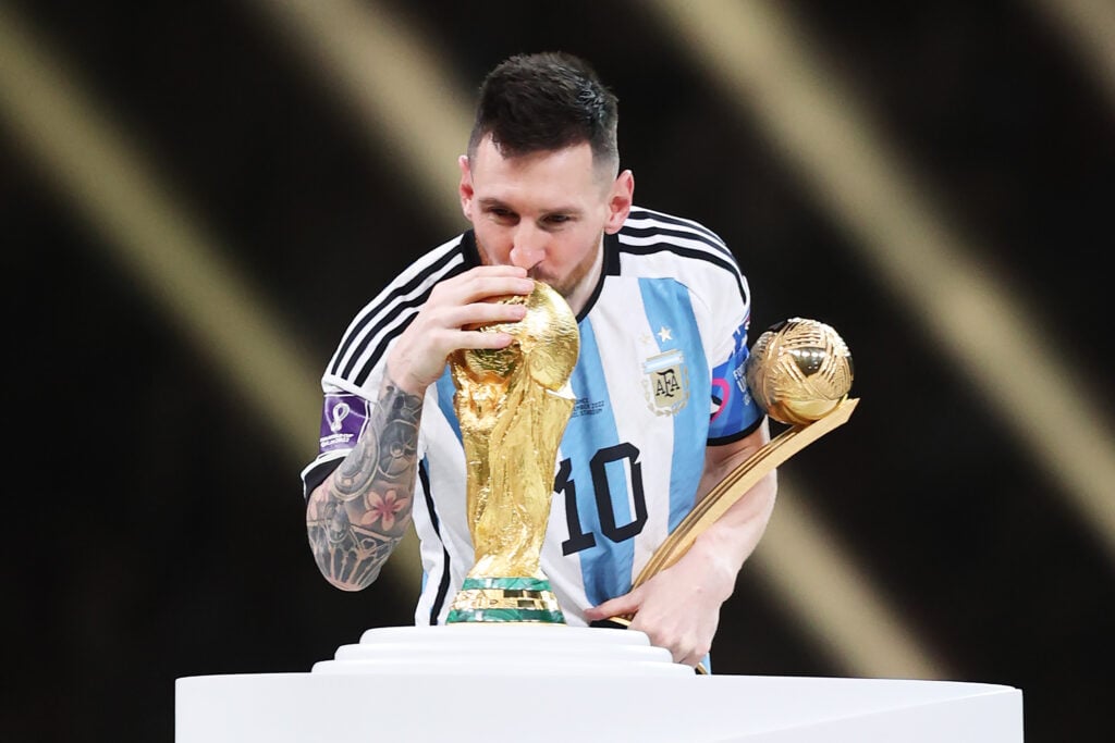 Lionel Messi kisses the World Cup trophy in 2022