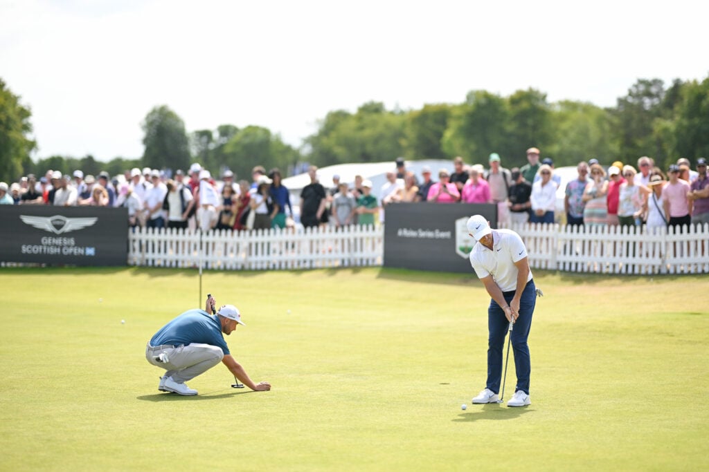Wyndham Clark and Rory McIlroy practice on the putting green during the final round of Genesis Scottish Open at The Renaissance Club