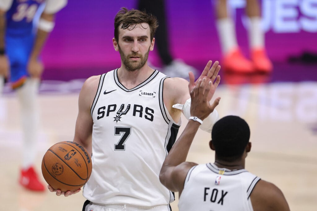 Luke Kornet #7 and De'aaron Fox #4 of the San Antonio Spurs celebrate a basket against the Oklahoma City Thunder during the fourth quarter in Game Four of the NBA Western Conference Finals at Frost Bank Center.
