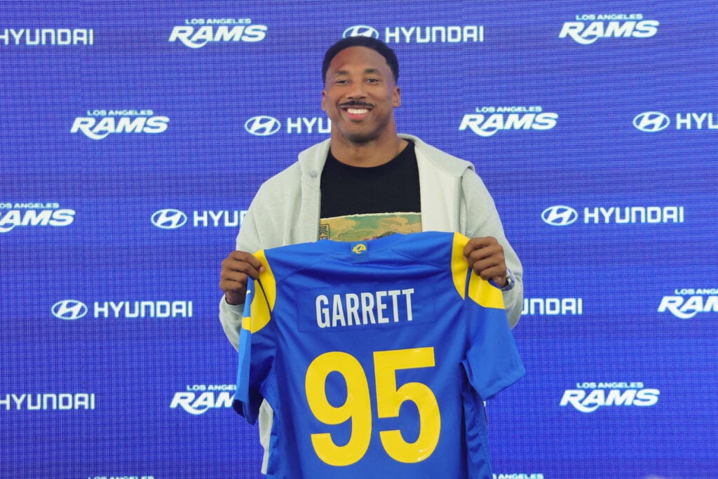 Myles Garrett #95 of the Los Angeles Rams poses with his jersey during a press conference after an organized team activities workout at Rams Village at the Warner Center.