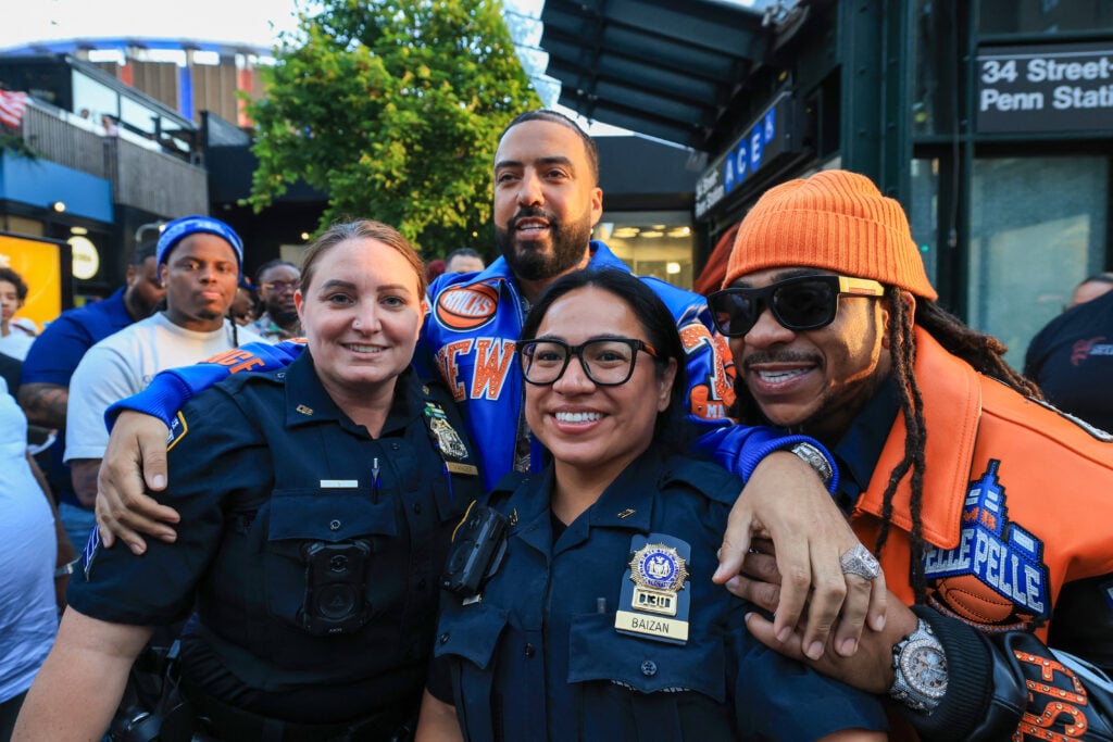 US rapper Memphis Bleek (R) and Moroccan-US rapper French Montana (C) pose for photos with NYPD officers outside Madison Square Garden ahead of Game 1 of the NBA Finals between the New York Knicks and the San Antonio Spurs, in New York City, on June 3, 2026.