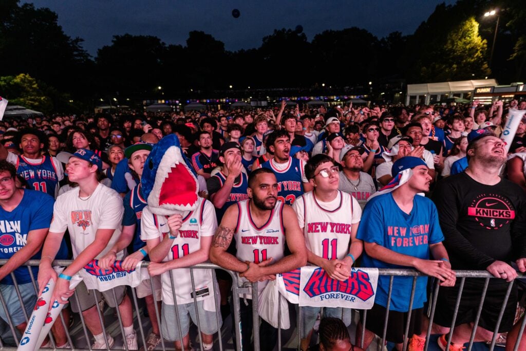 New York Knicks fans react during a watch party at the Wollman Rink in Central Park for Game 4 of the NBA Finals between New York Knicks and San Antonio Spurs, on June 10, 2026 in New York City. Madison Square Garden canceled its planned Game 4 watch party outside the arena after New York Knicks owner Jim Dolan criticized Mayor Zohran Mamdani and NYPD Commissioner Jessica Tisch over security requirements for the event.