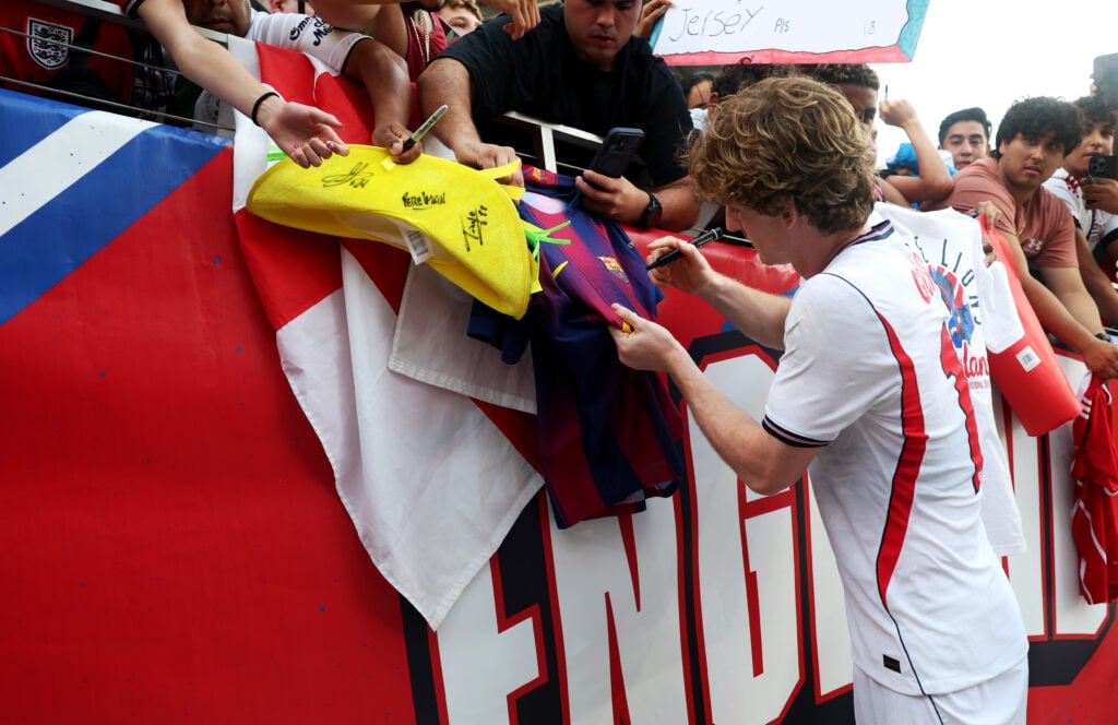 Anthony Gordon of England signs a fan's Barcelona shirt following victory at the end of the International Friendly match between England and Costa Rica