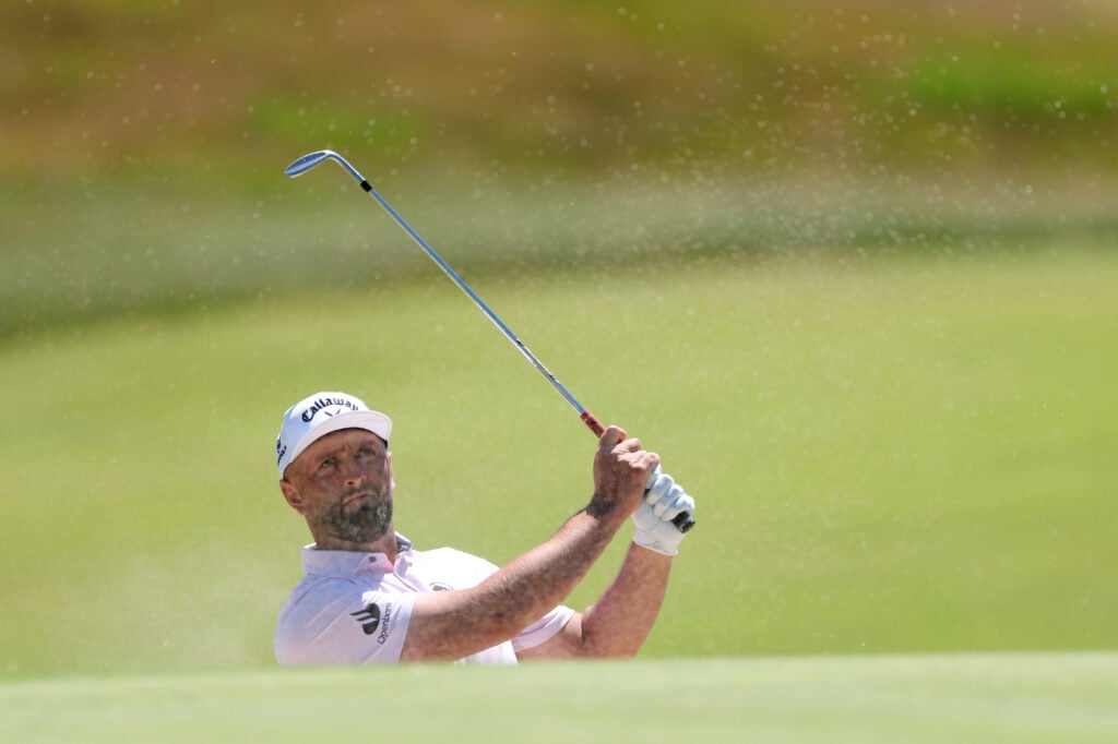Jon Rahm hits from a bunker during a practice round ahead of the US Open at Shinnecock Hills