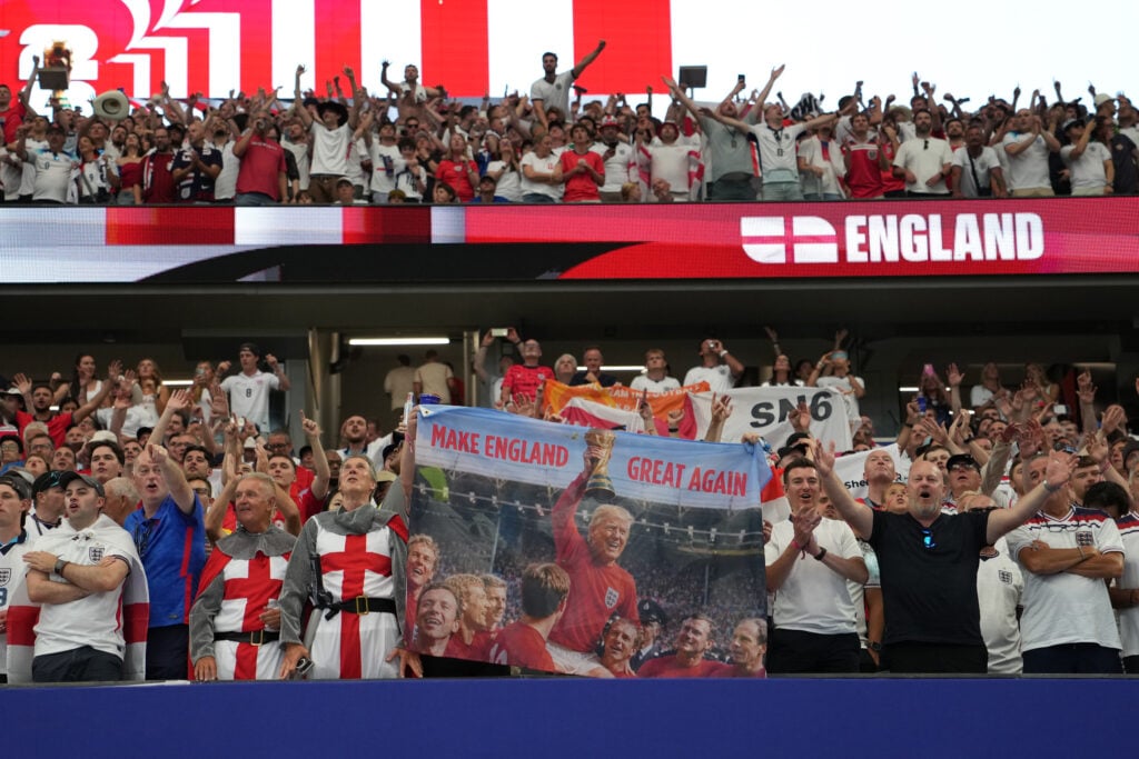 Supporters of England hold a banner reading "Make England Great Again", showing US President Donald Trump in an England uniform and holding the World Cup trophy during the FIFA World Cup 2026 Group L match between England and Croatia at Dallas Stadium.