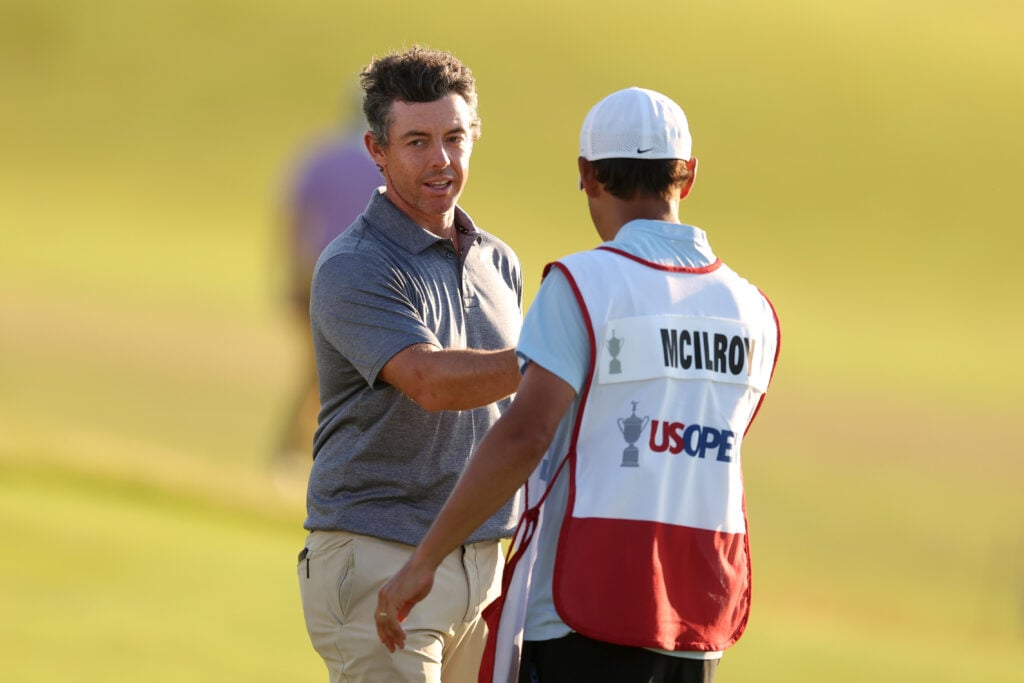 Rory McIlroy of Northern Ireland and caddie Harry Diamond shake hands on the 18th green after finishing their round during the second round of the 126th U.S. OPEN at Shinnecock Hills Golf Club
