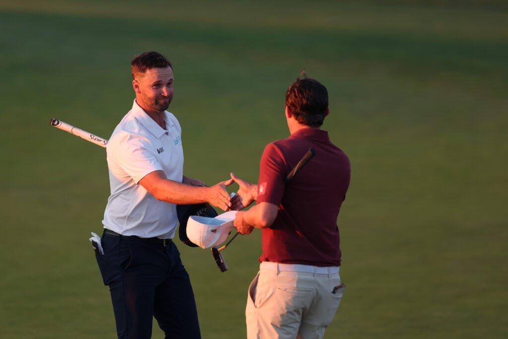 Wyndham Clark and Matt Fitzpatrick on the 18th green after finishing the third round of the U.S. OPEN at Shinnecock Hills