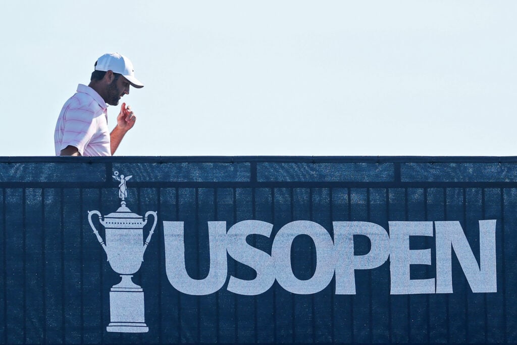 Scottie Scheffler walks across a bridge during the final round of the US Open
