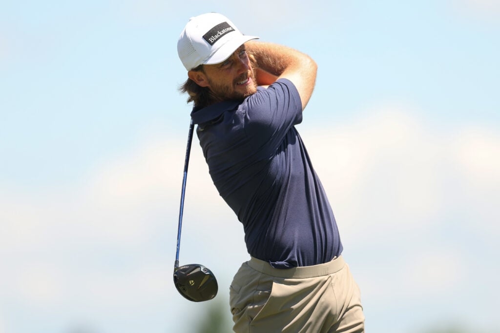 Tommy Fleetwood of England plays his tee shot from the third hole prior to the Travelers Championship 2026 at TPC River Highlands