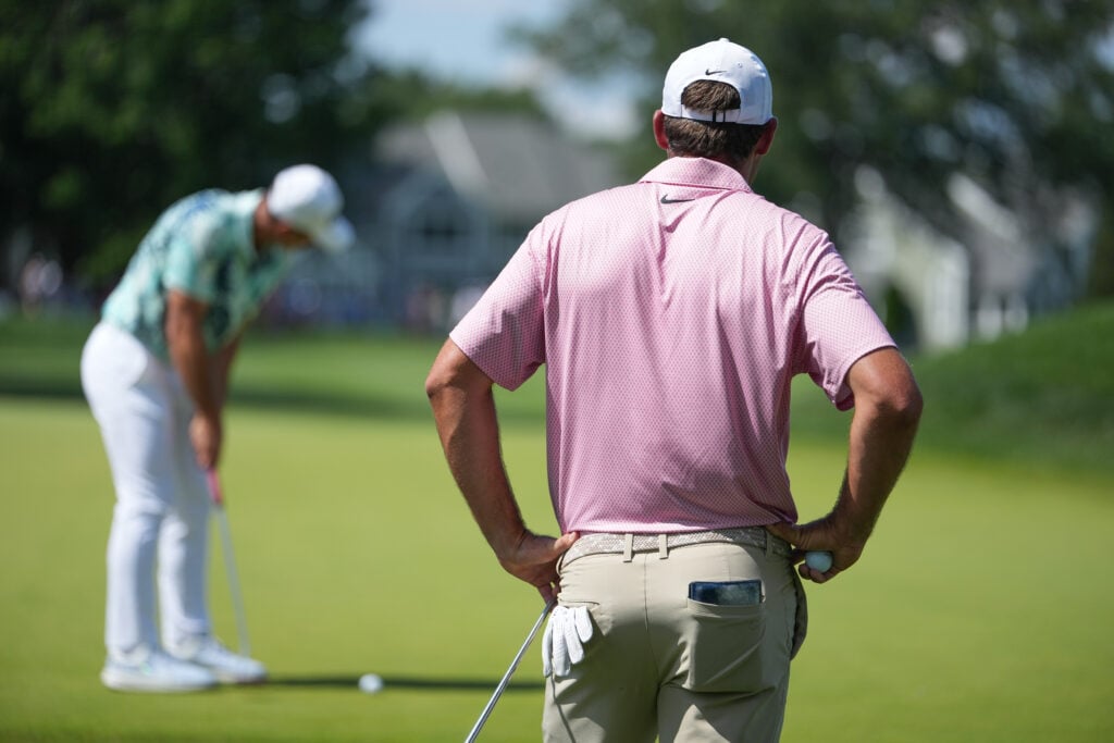 Scottie Scheffler looks on as Viktor Hovland putts during the final round of the Travelers Championship