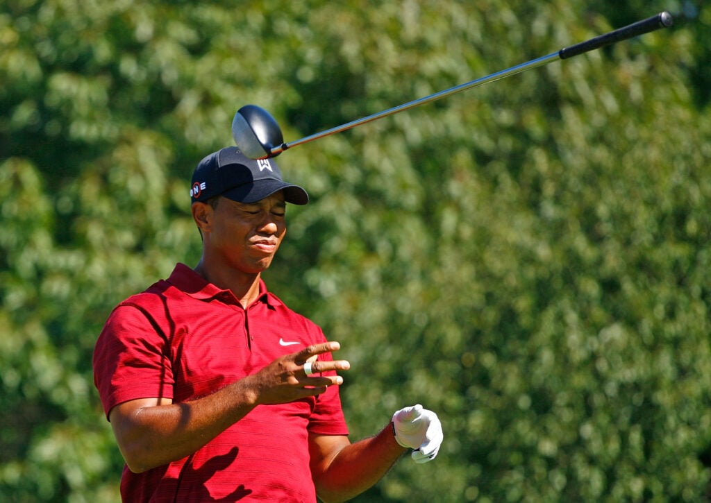 Tiger Woods tosses his golf club after a poor drive on the ninth hole during the final round of the BMW Championship held at Cog Hill