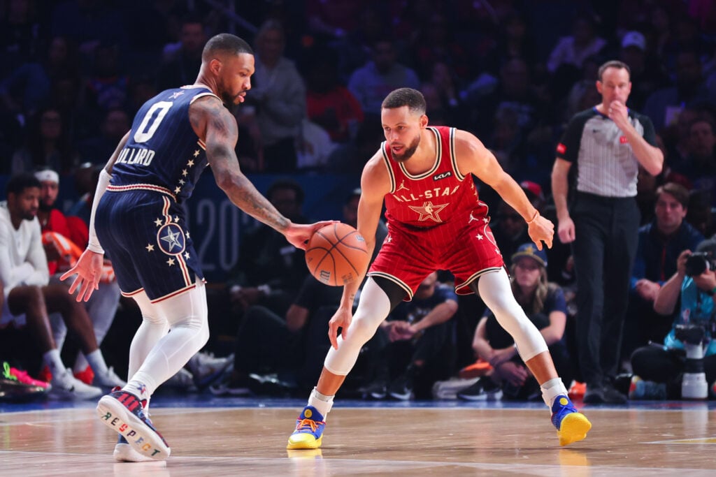 Damian Lillard #0 of the Milwaukee Bucks and Eastern Conference All-Stars dribbles the ball against Stephen Curry #30 of the Golden State Warriors