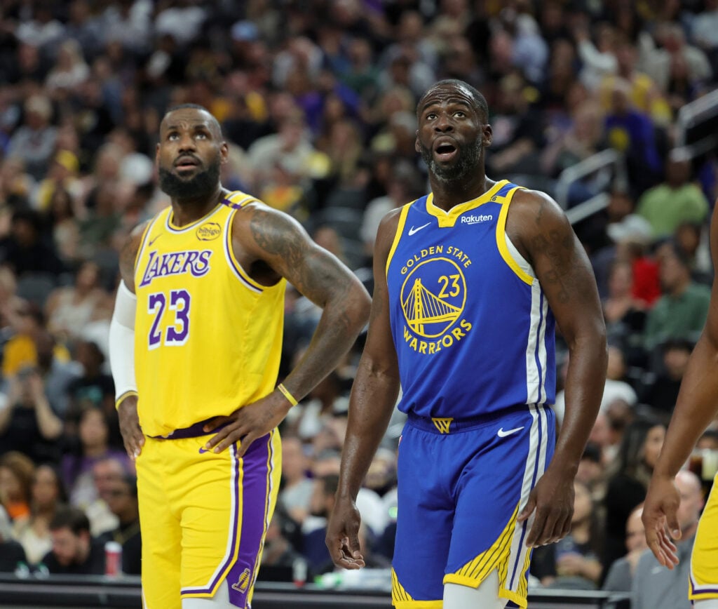 LeBron James #23 of the Los Angeles Lakers and Draymond Green #23 of the Golden State Warriors watch as a Warriors player shoots a free throw in the first quarter of their preseason game at T-Mobile Arena at T-Mobile Arena on October 15, 2024