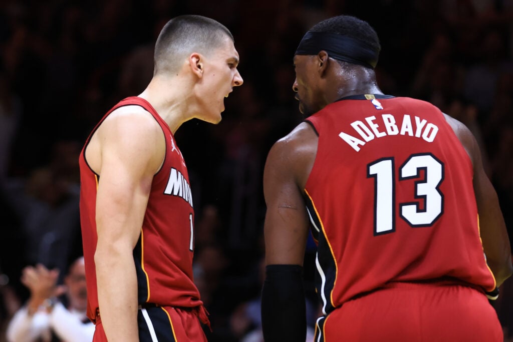 Tyler Herro #14 and Bam Adebayo #13 of the Miami Heat react against the Milwaukee Bucks during the fourth quarter of the Emirates NBA Cup at Kaseya Center.